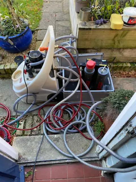 Power flushing pump, hoses and system chemicals set up outside a home by Homely Heating Group