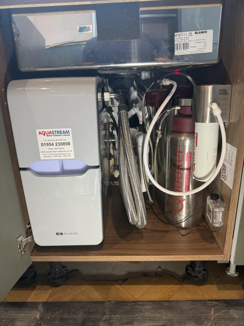 Water softener and pipework installed under a kitchen sink by Homely Heating Group